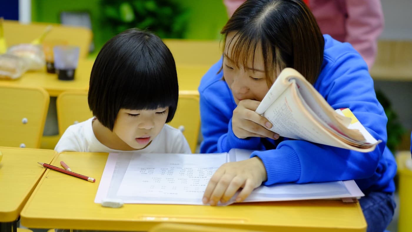 Educator connecting with a young child in a warm classroom